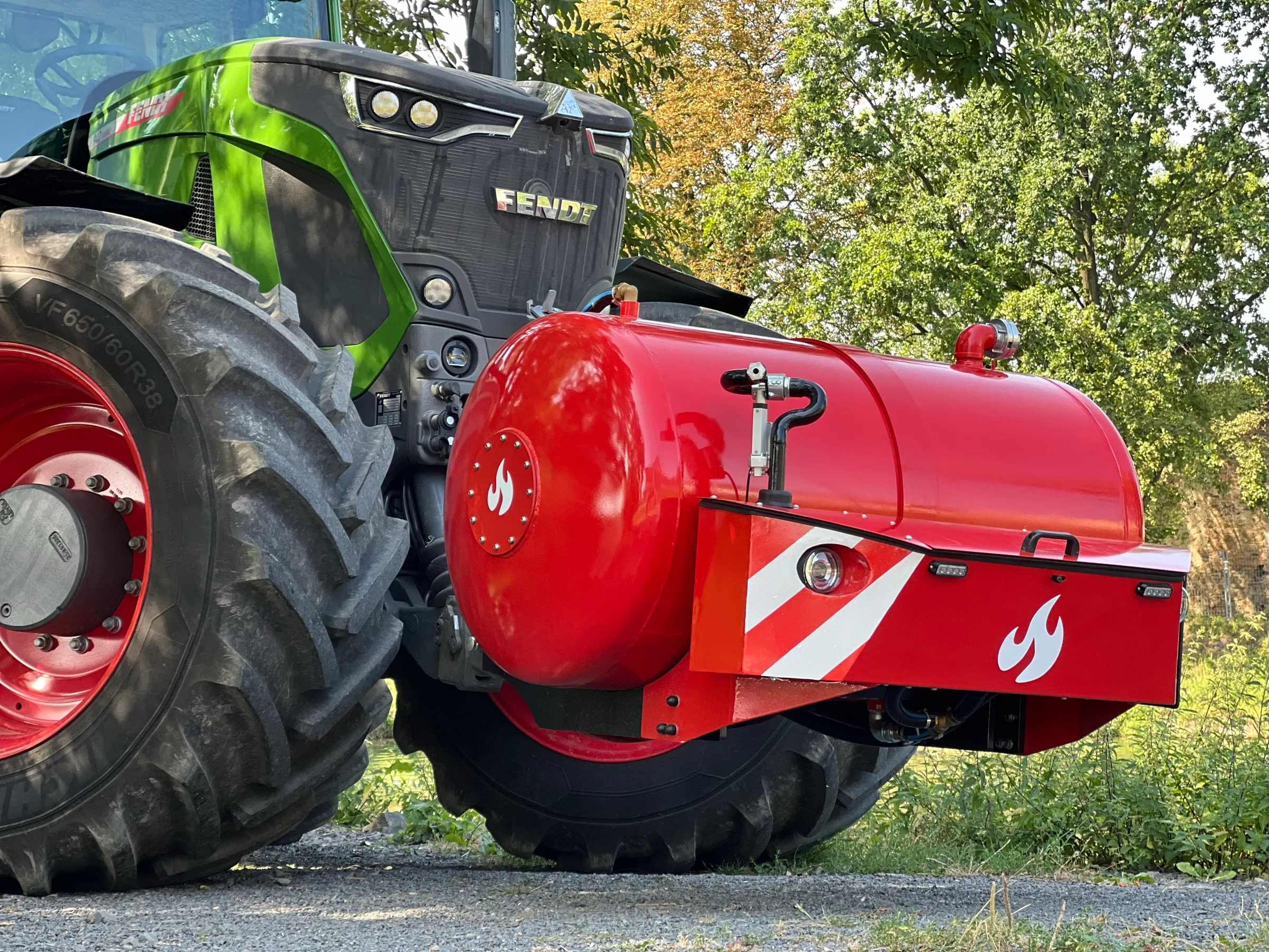 Nádrž HYDROTANK z boku na čelním závěsu traktoru Fendt, s předním boxem a výstražnými pruhy