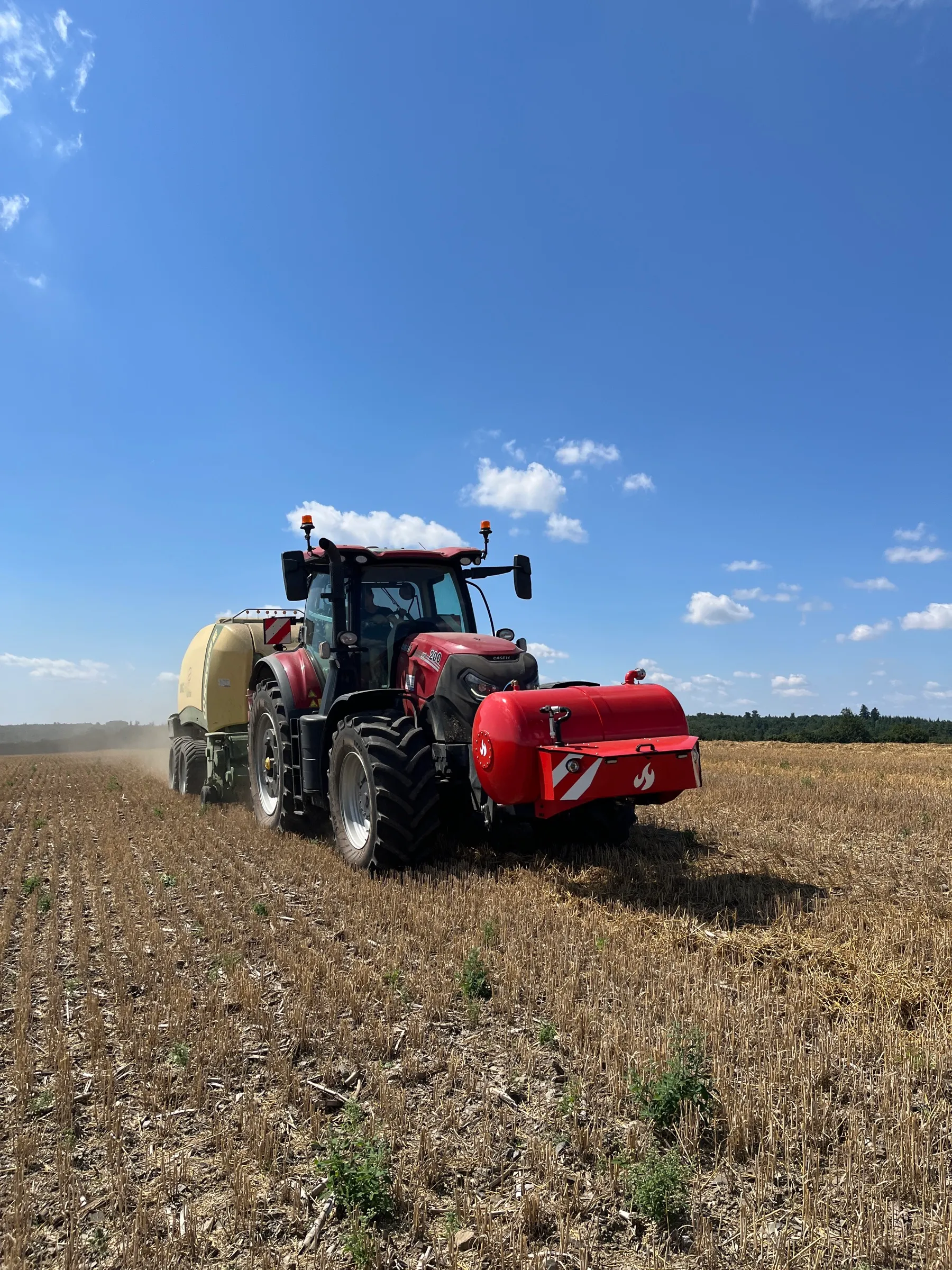 Traktor Case IH s Patronem a velkoobjemovým lisem při sklizni slámy